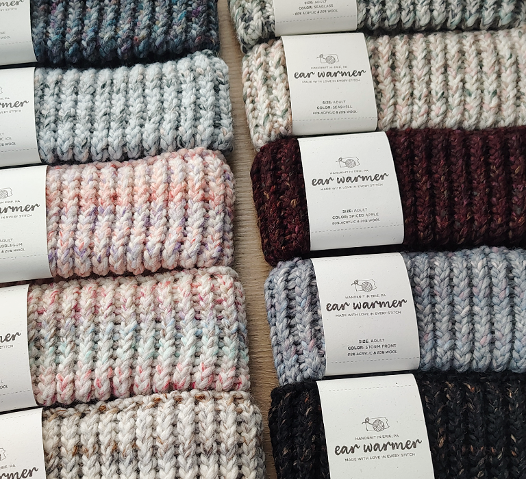 different colors of knitted ear warmers on a table