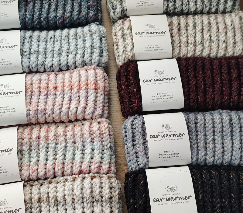 different colors of knitted ear warmers on a table