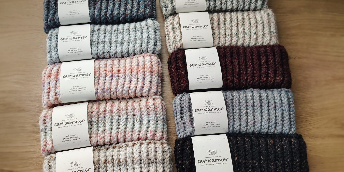 different colors of knitted ear warmers on a table